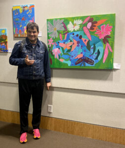 James Takhar standing beside his piece "Eternal Bloom."